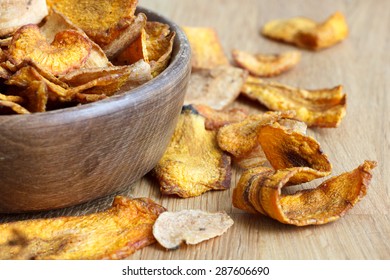 Detail Of Fried Carrot And Parsnip Chips In Rustic Wood Bowl.