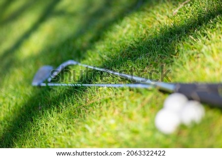 Detail of Golf clubs  and balls on green, selective focus, light and shadows. Background for golf, sport, resort, vacation. Stock photo © 