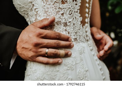 Detail Of A Groom's Hand On The Waist Of His Bride. Couple Embracing