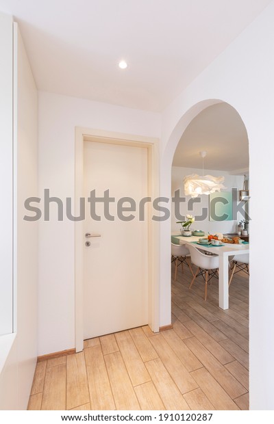 Detail from hallway of elegant and romantic white\
table ready for breakfast with brioche, cups for coffee and fruits.\
Nobody inside