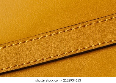 Detail of handbag with stitching, genuine leather of bright yellow color. Texture and fashionable modern background, copy space