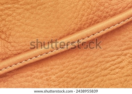 Detail of handbag with stitching, vintage genuine leather of yellow brown color. Texture and background, copy space