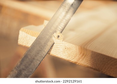 Detail of a hand-cutting blade notching the first corners of a board, obtaining wood curls and bevels in the surface, often intentionally irregular. Wood craftsmanship.