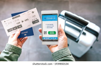 Detail Of Hands Holding A Mobile With Covid Passport And Boarding Pass