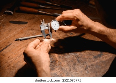 Detail of the hands of a luthier making measurements - Powered by Shutterstock