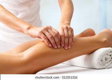 Detail of hands massaging human calf muscle.Therapist applying pressure on female leg. - Powered by Shutterstock