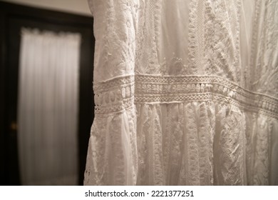 A Detail Of A Hanging Beautiful White Lace Dress