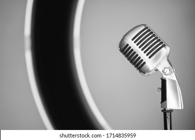 Detail Of Horizontal Side View Of Old Style Metallic Microphone Inside A Professional Circle Light. Vintage Silver Microphone Isolated On White Background. Retro Oldies Music Concept.