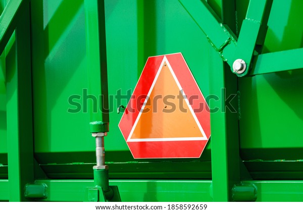Detail industry\
agricultural machine with reflective slow moving vehicle warning\
sign in triangle shape