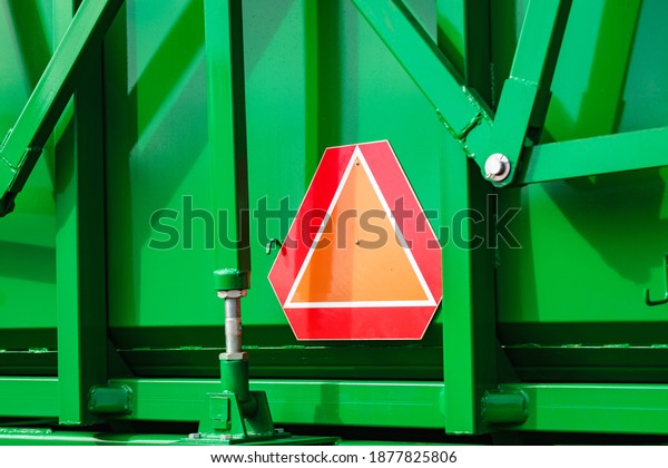 Detail industry\
agricultural machine with reflective slow moving vehicle warning\
sign in triangle shape