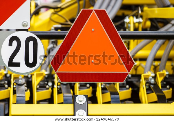 Detail industry machine with reflective\
slow moving vehicle warning sign in triangle\
shape
