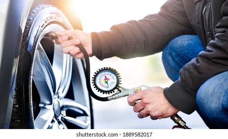 Detail of inflating tire and checking air pressure use gauge in mechanics hands.  - Powered by Shutterstock