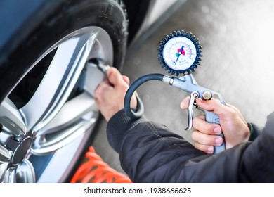 Detail of inflating tire and checking air pressure use gauge in mechanics hands.  - Powered by Shutterstock