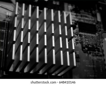 Detail of the interior of a computer with a square slatted component. Black and white photography.
