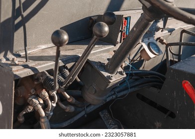 Detail of the interior of an old tractor in an industrial environment.close-up on the levers inside