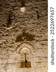 Detail of the intricate stone relief work and arches embellishing the Zion Gate in the Old City of Jerusalem lit up at night.