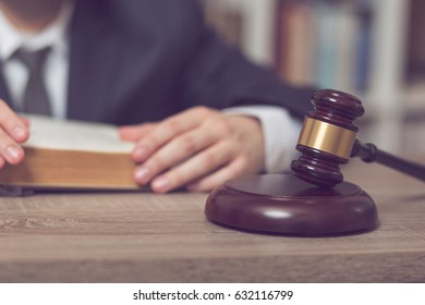 Detail Of A Judge Sitting At His Desk, Studying New Laws And Legislation. Selective Focus