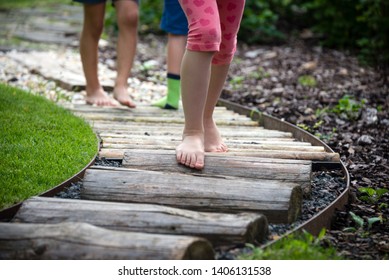 Detail Of Kids Legs Walking On Wooden Pathway Barefoot