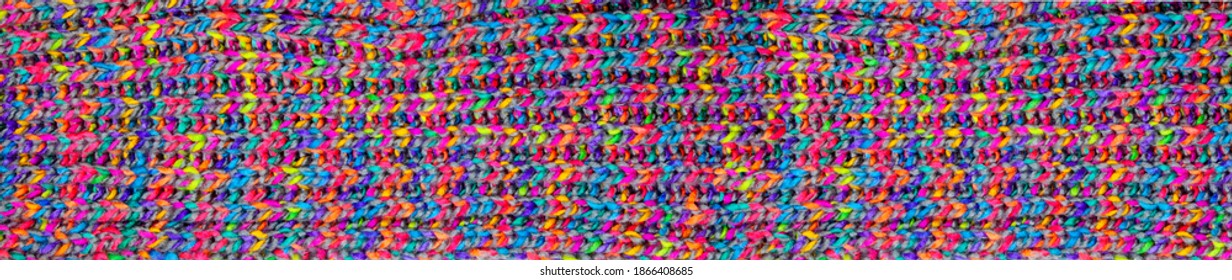 Detail of knitwear of a shawl. knitted fabric texture. Texture of mulicolored knit scarf. Large knitting. panoramic web banner Top view