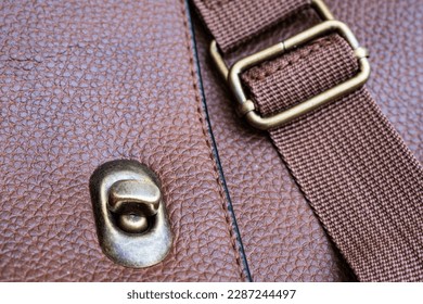 Detail of a leather bag close-up. Leather metal buckle on bag macro closeup