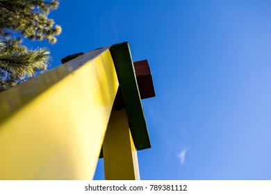 Detail From The Legs Of A Swing Set And Other Parts Of A Child's Swing In The Park With The Blue Sky Above In The Background