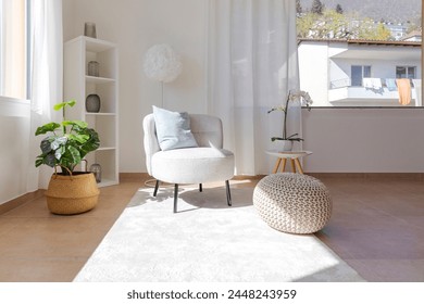 Detail of a living room corner with a small armchair with a coffee table and a pouf resting on the carpet. No one inside - Powered by Shutterstock