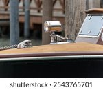 Detail of a luxury water taxi in Venice, showing polished chrome fixtures and wooden deck. Iconic Venetian craftsmanship in water transportation.