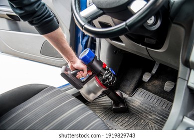 Detail of a male hand cleaning the interior of a car using a handheld portable vacuum cleaner. - Powered by Shutterstock