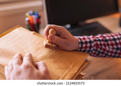 Detail Of Male Hand Putting Stamp On Envelope, Sending Mail; Small Business Owner Packing Products For Delivery; Entrepreneur Getting Online Store Orders Ready For Shipping