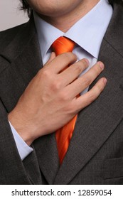 Detail of a man, fixing his tie - isolated in soft light