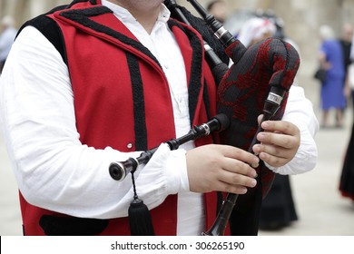 Detail Of A Man Playing The Galician Bagpipe, Dressed In A Traditional Costume Of Galicia, Northwestern Spain