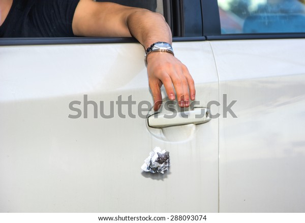 Detail of Man Wearing Wrist Watch\
Tossing Crumpled Ball of Refuse Out of Car Window onto Ground,\
Close Up of Irresponsible Man Littering Garbage from\
Car