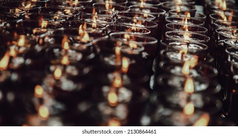 Detail of Many red votive candles light inside Chinese temple. Rows of Votive Candles in Glass with shallow depth of field, Blurred of candles, Red Candle is kindle a fire in glass, Focus and blur.