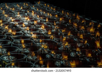 Detail of Many red votive candles light inside Chinese temple. Rows of Votive Candles in Glass with shallow depth of field, Blurred of candles, Red Candle is kindle a fire in glass, Focus and blur.