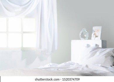 
Detail Of Messy Bedding In All White Bedroom With Window