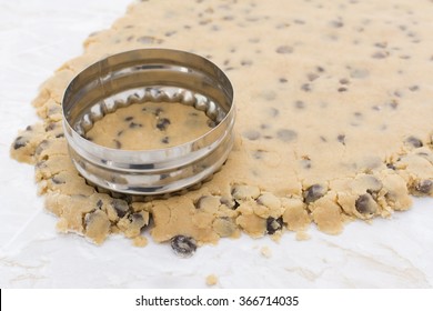 Detail Of Metal Cookie Cutter Cutting Circle From Chocolate Chip Cookie Dough On A Kitchen Worktop