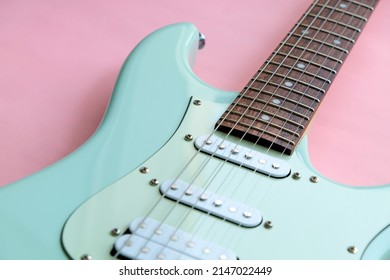 Detail of Mint Green Electric Guitar on a Pink background.