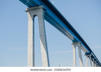 Detail of modern concrete tall bridge against blue sky background with copy space
