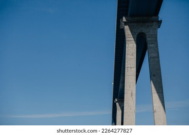 Detail of modern concrete tall bridge against blue sky background with copy space