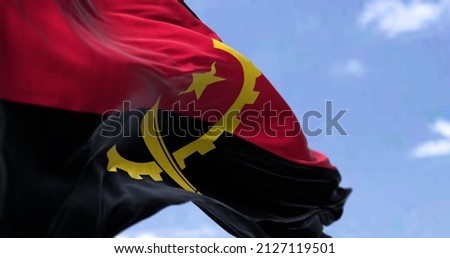 Detail of the national flag of Angola waving in the wind on a clear day. Angola is a country on the west coast of Southern Africa. Selective focus.