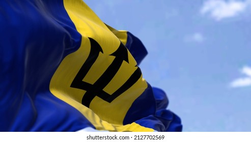 Detail of the national flag of Barbados waving in the wind on a clear day. Barbados is an island in the Lesser Antilles of the West Indies, in the Caribbean region of the Americas. Selective focus.
