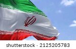 Detail of the national flag of Iran waving in the wind on a clear day. Islamic republic. Patriotism. Western asian country. Selective focus.