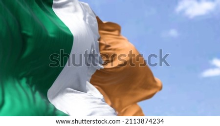 Detail of the national flag of Ireland waving in the wind on a clear day. Democracy and politics. Northern Europe country. Patriotism. Selective focus.