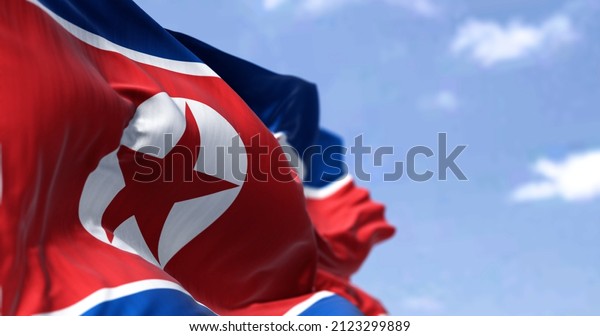 Detail of the national flag of North Korea\
waving in the wind on a clear day. Patriotism. Selective focus.\
East asia country.