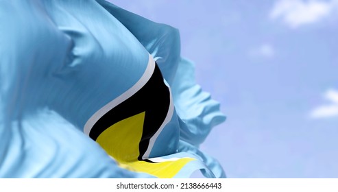Detail of the national flag of Saint Lucia waving in the wind on a clear day. Saint Lucia is an island country in the West Indies. Selective focus.