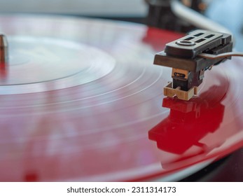 Detail of a needle on a track of a red vinyl record. Vintage turntable. - Shutterstock ID 2311314173