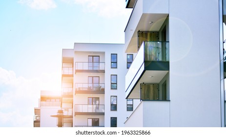Detail of new luxury house and home complex. Glass surface with sunlight. Rising sun on the horizon. Part of modern residential apartment with flat building exterior.  Velvia graphic filter. - Shutterstock ID 1963325866