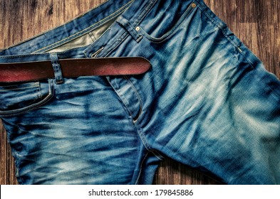 Detail of nice blue jeans with leather belt in vintage style