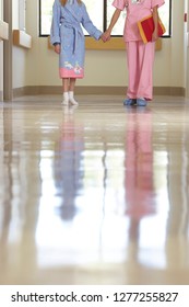 Detail Of Nurse And Child Patient Walking Along Hospital Corridor