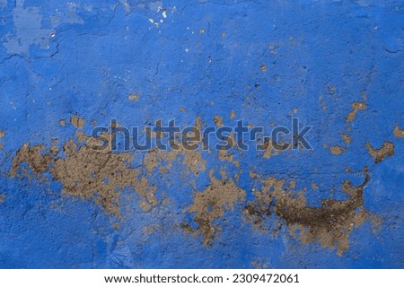 Detail of old blue painted wall texture with scraps of flaking pait 